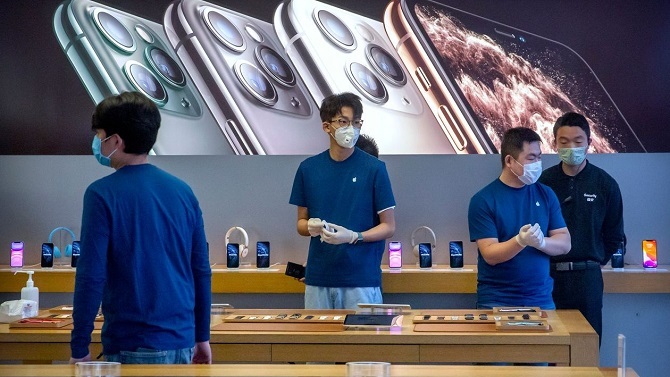 Các nhân viên Apple Store ở Bắc Kinh phải đeo khẩu trang trong ngày mở cửa trở lại. Ảnh: WSJ.